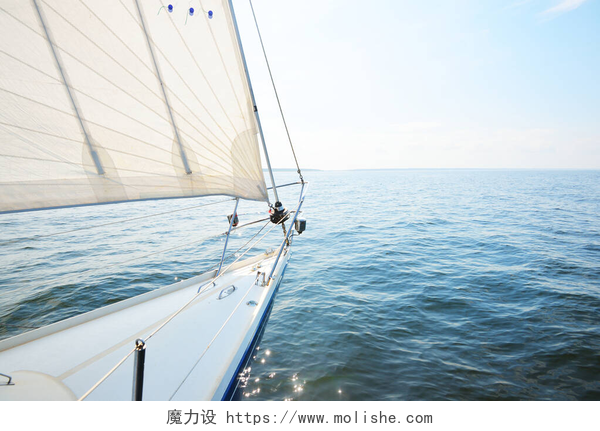 蓝天白云下的大海和帆船在阳光明媚的夏日,白色游艇航行.从甲板到船头、桅杆和船帆,俯瞰全景.浪花和水花四溅.晴朗的蓝天。芬兰湾
